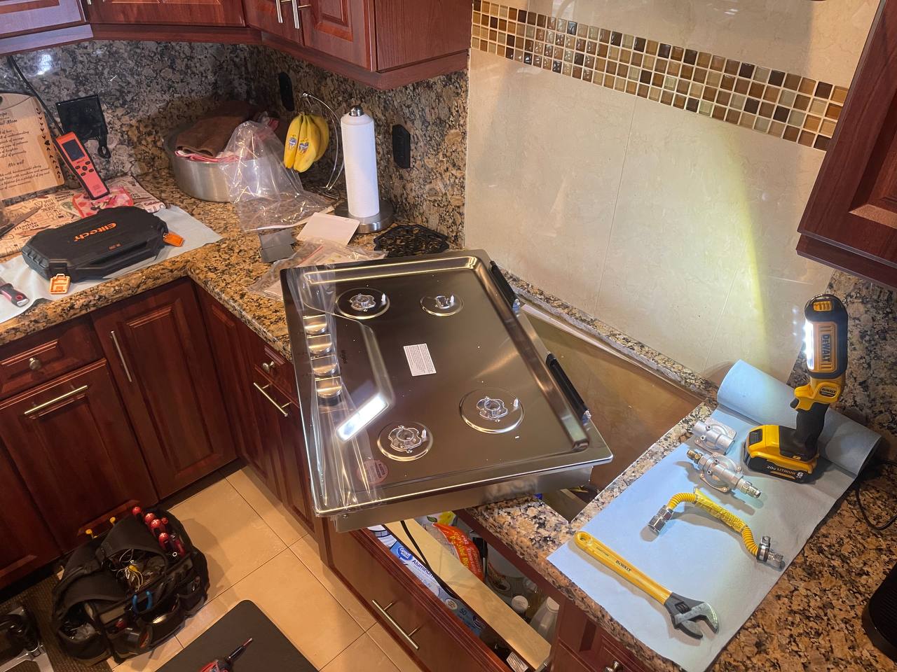 Cooktop removed for access to components on a protected counter.